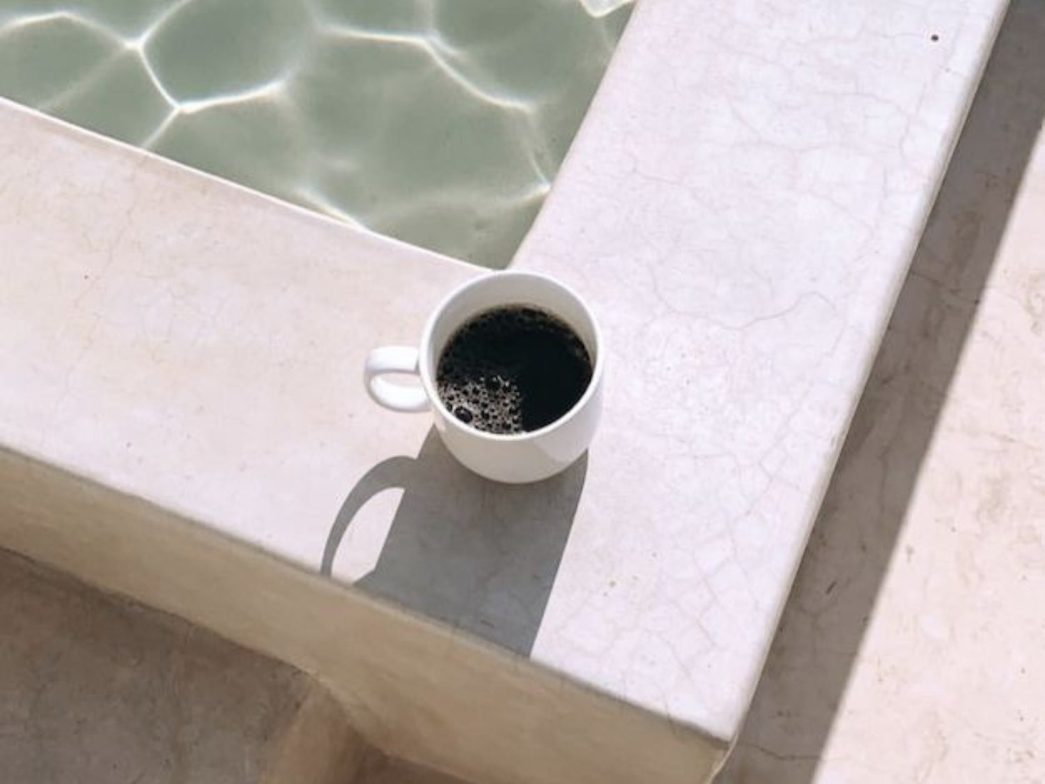 Blog Post graphic - Recession Proof Your Online Store - Cup of coffee by a swimming pool